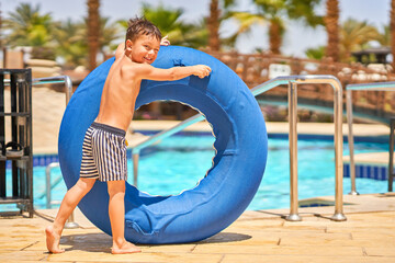 Picture of a small boy having fun in aquapark outdoor on tube