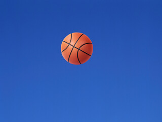 A basketball shot in the air with blue sky background