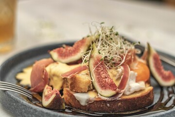 Closeup of fig and jam toast on a rustic table with golden drink