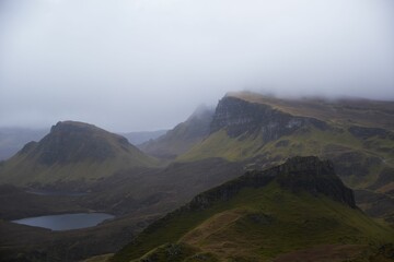 Fototapeta premium Stunning landscape of a picturesque lake and steep mountains on a foggy day