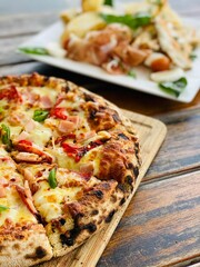 Freshly prepared pizza with delicious toppings of meat, cheese, and lettuce resting on a table