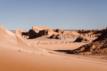 Landscape of the desert featuring large sandy dunes rolling across the horizon