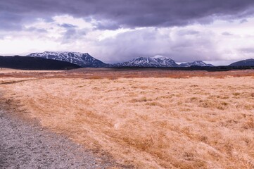 Picturesque dirt road cutting through a vast landscape of rolling hills and mountains