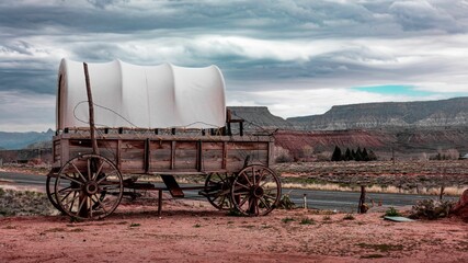 Rustic wooden covered wagon in a remote desert landscape with no people