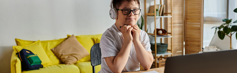 adorable boy with Down syndrome engaged with laptop.