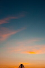 Vertical shot of a vibrant sunset over a picturesque landscape of fields and clouds