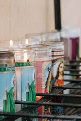 several candles of religious icons on the table in front of them