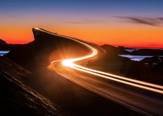 Stunning long exposure shot of light streaks on the Atlantic Ocean Road in Norway