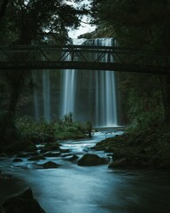 Vertical of a bridge overlooking a powerful waterfall cascading into a river below