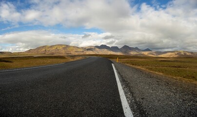 Fototapeta premium View of an empty stretch of highway winding through a spectacular mountain range in Iceland