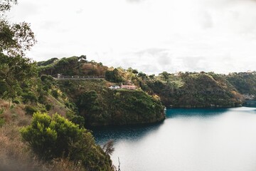 Aerial view of a tranquil sea surrounding lush, green forested hillside
