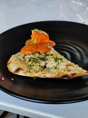 Closeup shot of Dal Bukhara and Naan oil served on a black plate