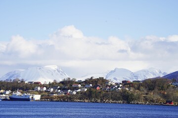 Aerial view of Alesund cityscape, Norway, with snow-capped mountains in the background