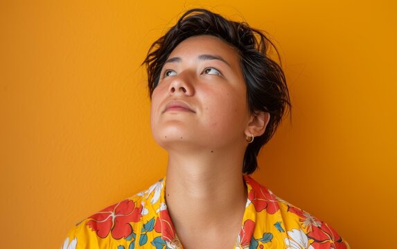Polynesian adult in a colorful shirt looking up