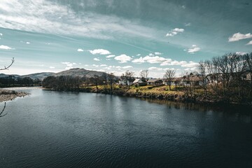 Scenic view of houses on a riverbank on a sunny day in Fort William, Scotland