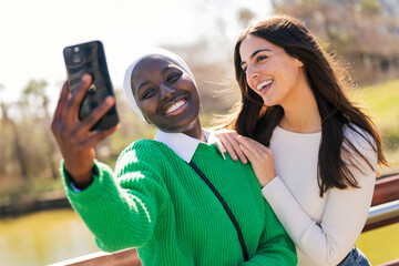 female friends having fun taking selfie with phone