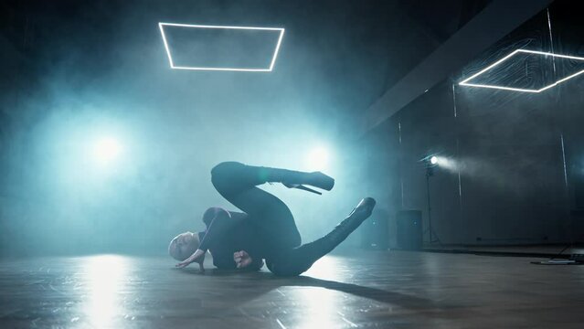 Elegant female dancing in dark studio with smoke and spotlight. Woman dancing indoors. Sensual choreography in smoky studio with beautiful light. High heels. 4K, UHD