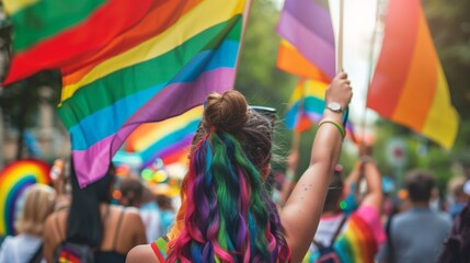 Crowd celebrating with rainbow flags at a public event