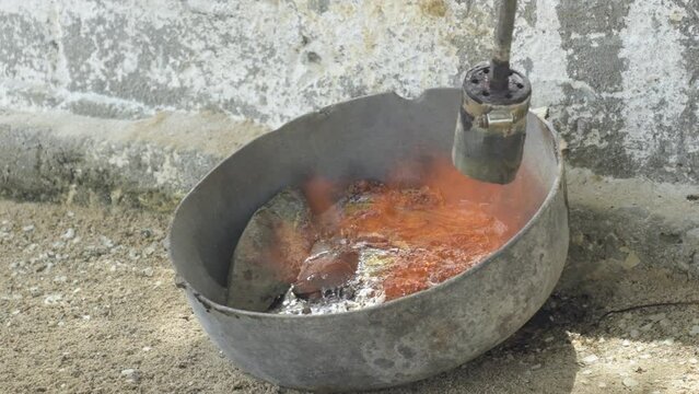 Fire lighter to melt lead in a pot in rustic way to make Fishing Sinkers Weights
