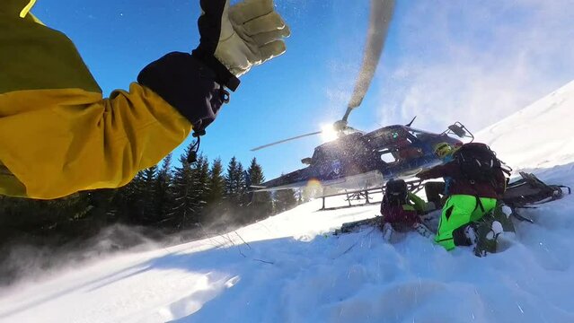 Group of friends on a beautiful winter sunny day entering chopper for freeride skiing in fresh powder snow 