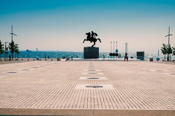 the statue of a man riding a horse in front of the ocean
