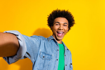 Photo of nice young man make selfie wear denim shirt isolated on yellow color background