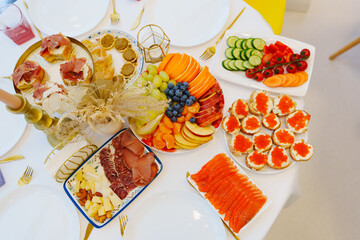 A set table with snacks. sandwiches with caviar, salted fish, fruits and vegetables.