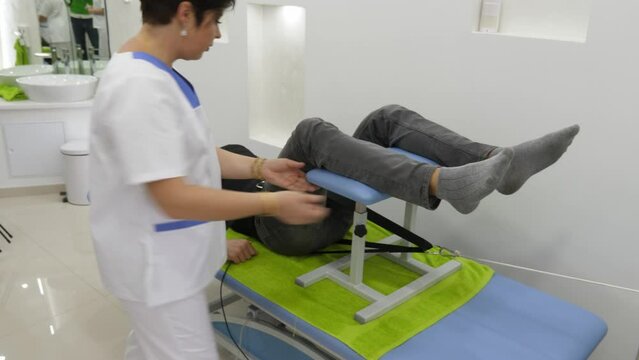 A physiotherapist monitoring a patient during the back stretching