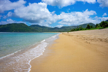  Beautiful sandy beach stretching along the turquoise waters in Lombok, Indonesia, under a clear summer sky