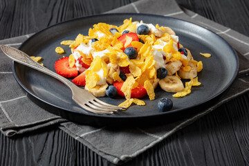 fresh berries, banana with corn flakes and yogurt