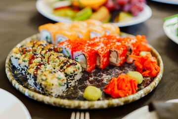 A large plate with rolls. A set of assorted rolls for the holiday. Ordering and delivery of Japanese cuisine.
