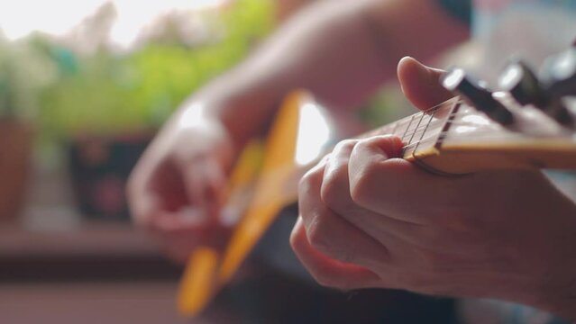 Male hand playing traditional Turkish instrument baglama