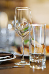 An empty wine glass and a glass on the served dining table. tableware for a banquet. catering services for the holiday.