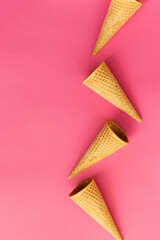 Empty wafer ice cream cones on pink background. Isolated top view, summer concept, mockup for...
