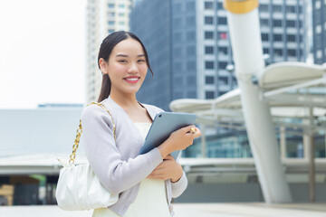 Young Asian confident business woman is going to the office or workplace which she look at camera...