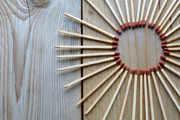 A circle from matches on the wooden background. Many long matches in circle form for men