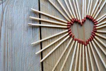 Heart from matches on the wooden background. Many long matches in heart form for men
Heart from matches on the wooden background. Many long matches in heart form for men