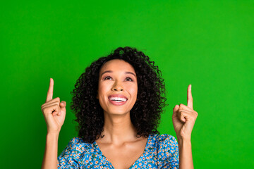 Photo of nice young woman point fingers up empty space wear top isolated on green color background