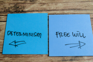 Concept of Determinism or Free will write on sticky notes isolated on Wooden Table.