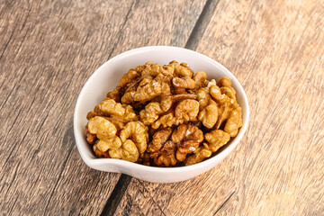 Cracked unshelled walnut in the bowl