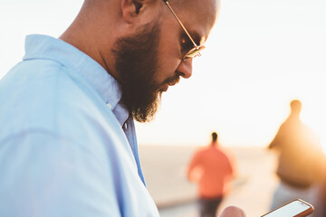 Selective focus, hipster guy checking mail on smartphone sending message via good internet...