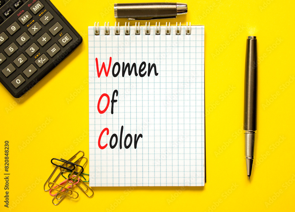 Wall mural WOC women of color symbol. Concept words WOC women of color on beautiful white note. Beautiful yellow background. Black calculator. Business WOC women of color social issues concept. Copy space.