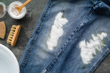 Powder baking soda on jeans. The concept of organic removing grass stains on clothes. Zero waste...