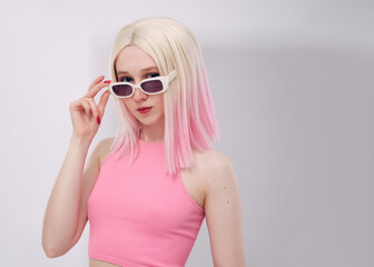 Naklejka premium A beautiful woman in a pink vest and glasses on a white background