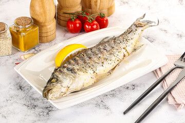 Grilled sea bass fish served lemon