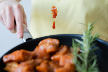 Close up drops tomato sauce or ketchup on yellow clothes. An unrecognizable woman holding a pastry...