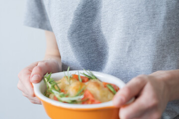 Close up dirty grease stain on gray clothes. An unrecognizable woman holding a pastry in her hands. daily life stain concept. 