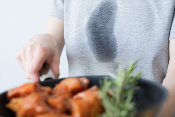 Close up dirty grease stain on gray clothes. An unrecognizable woman holding a pastry in her hands. daily life stain concept. 