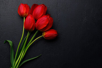 Red tulips grace the table, providing a serene and vibrant backdrop