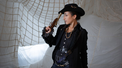 A pirate lady in a hat with a vintage pistol in her hands,
